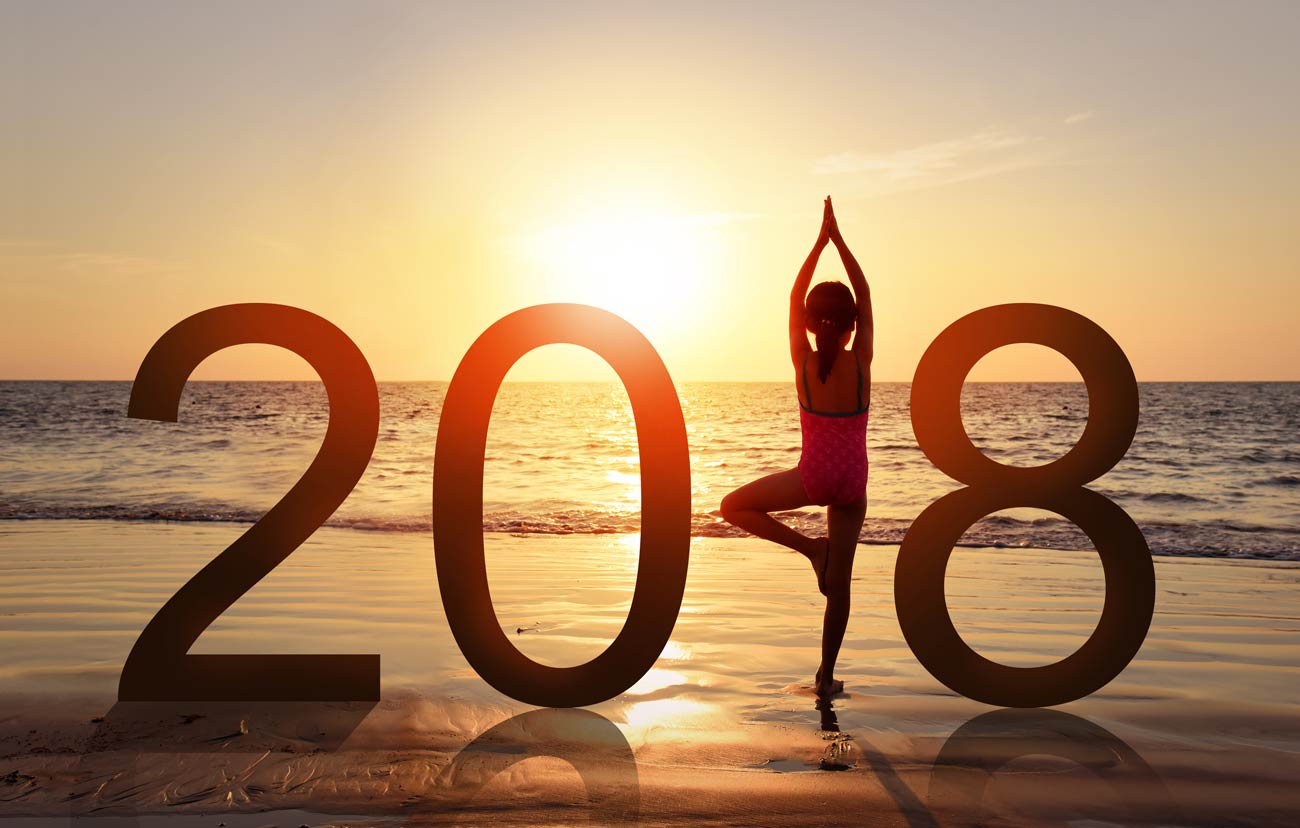 Silhouette of A girl doing Yoga on a sunset beach, standing as a part of the Number 2018 sign