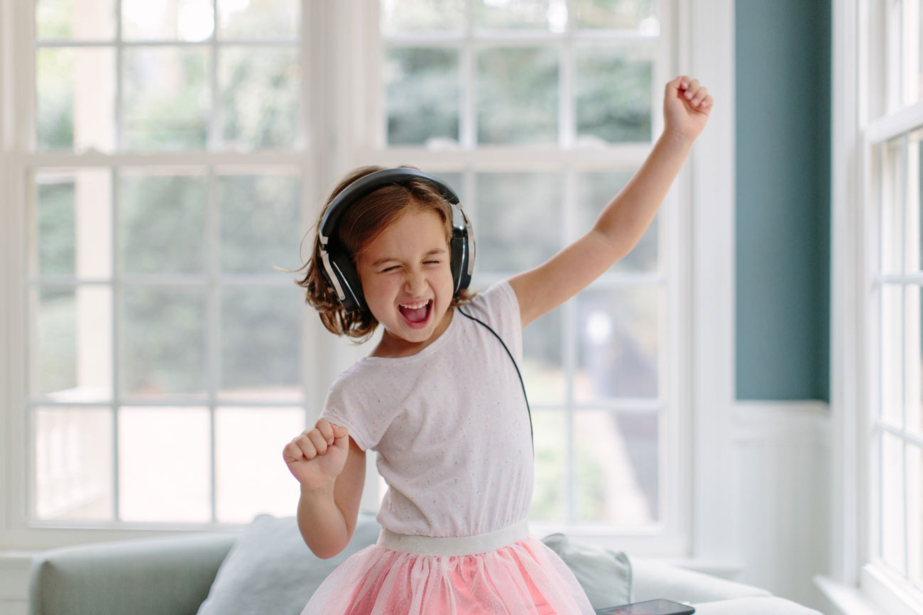 young girl listening to music on headphones