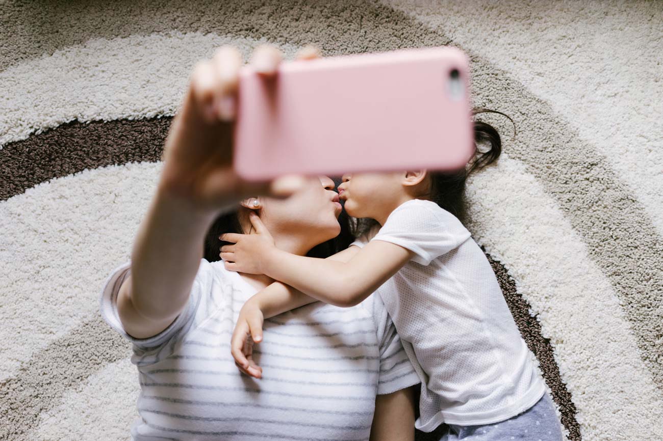 Adorable little girl with her mother taking selfie