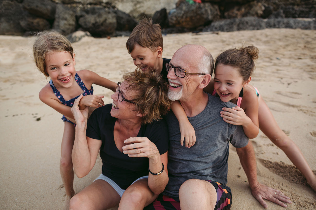 A couple with their grandkids on the beach.